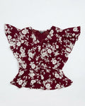 A burgundy floral blouse with dramatic ruffled sleeves and a peplum hem, laid flat against a white background.