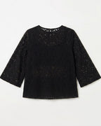 A black lace long-sleeve top with a round neckline, laid flat against a light off-white background.