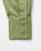 Close-up of a sage green long-sleeve shirt cuff with two button closures, shown on a clean white background.