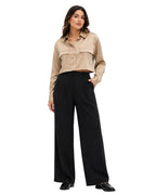 A woman modeling a cropped beige button-up shirt with chest pockets and black wide-leg trousers, standing against a plain white background.