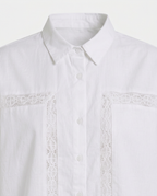 White long-sleeve button-up shirt with a pointed collar and decorative white lace trim running vertically on the chest pocket flaps.