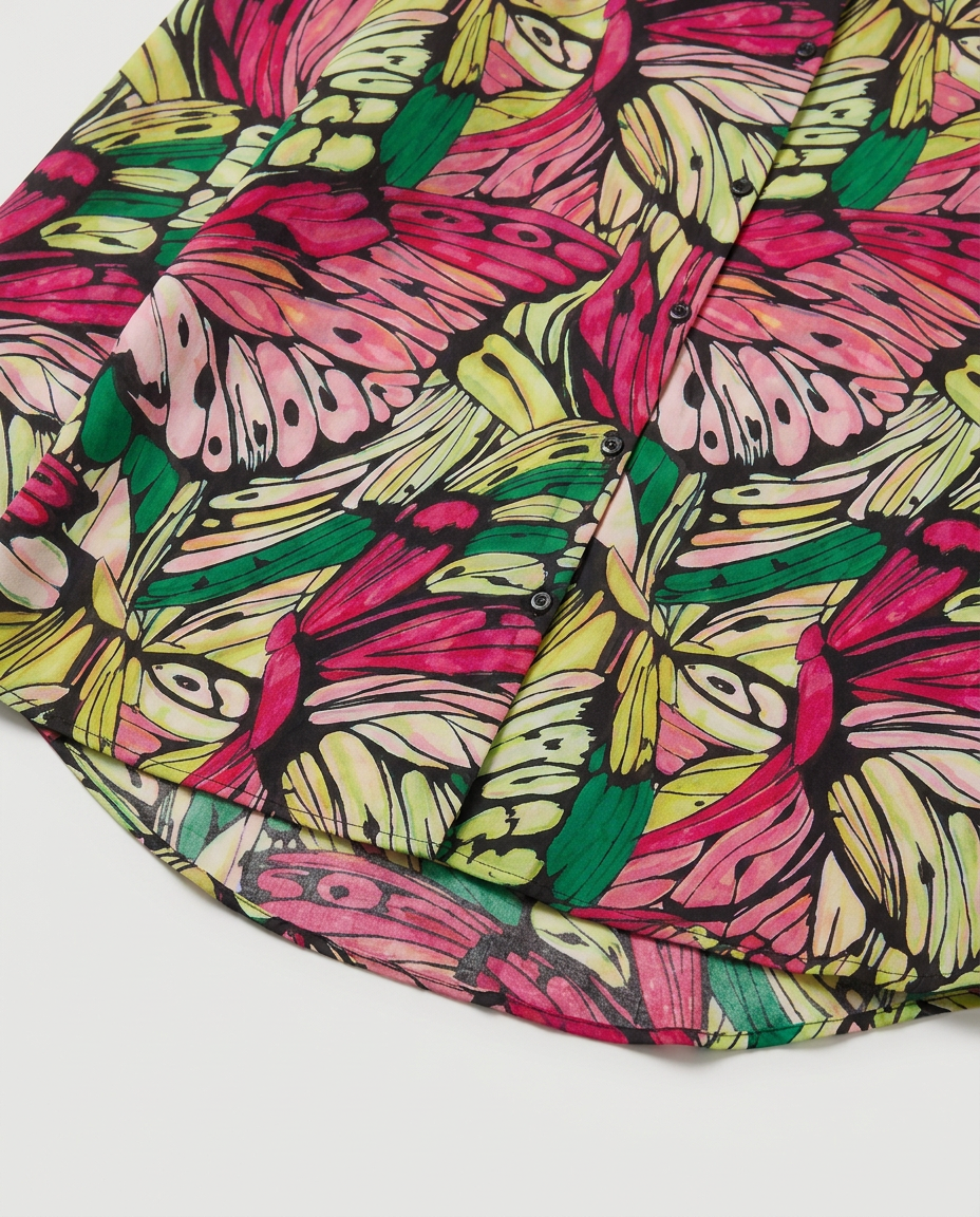 A close-up of a colorful butterfly print fabric, featuring vibrant pink, green, yellow, and light blue butterflies outlined in black on a white background.