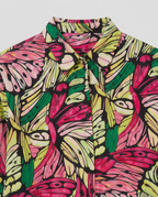 A close-up of a button-up shirt featuring a vibrant, hand-drawn butterfly and leaf pattern in pink, green, and yellow on a black background.