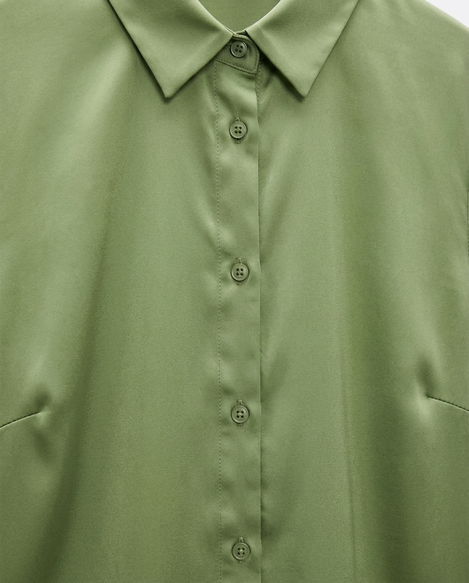 Close-up of a light olive green button-down shirt showing the collar, front buttons, and fabric texture.