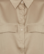 Close-up of a beige button-up shirt with a pointed collar, matching buttons, and two chest flap pockets.