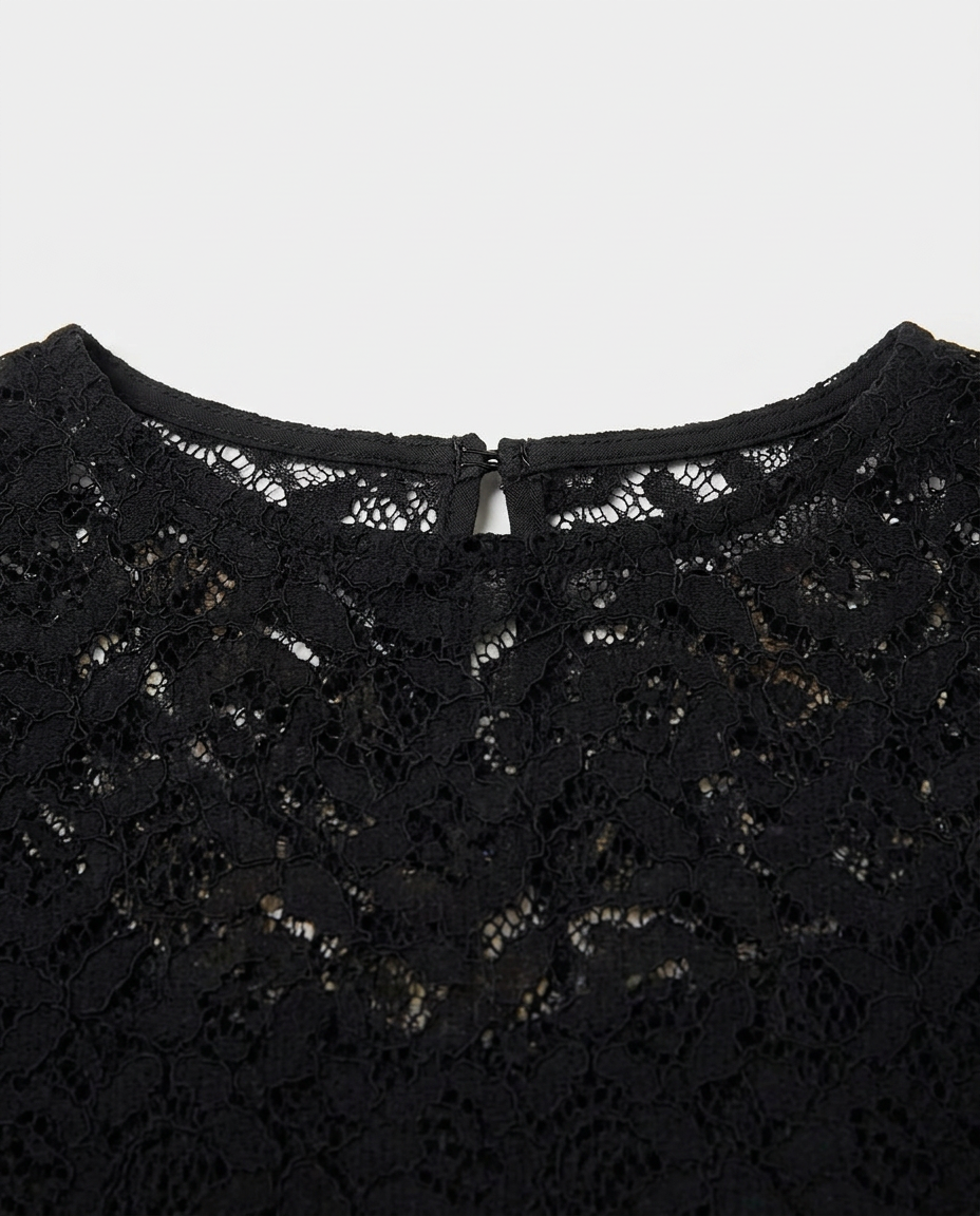 Close-up of a black lace top showing the intricate floral lace pattern and the inner neckline with a small keyhole cutout.